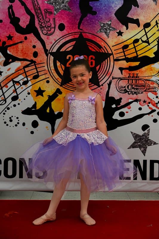 A young dancer in a purple tutu